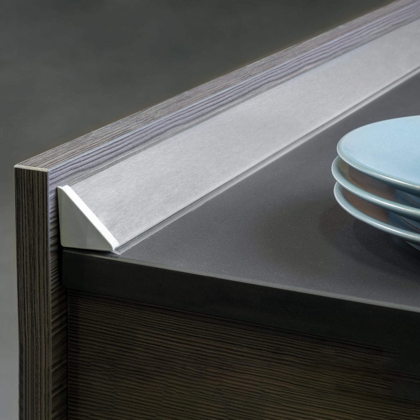 Alzatina triangolare per cucina Plasline con accessori per installazione.